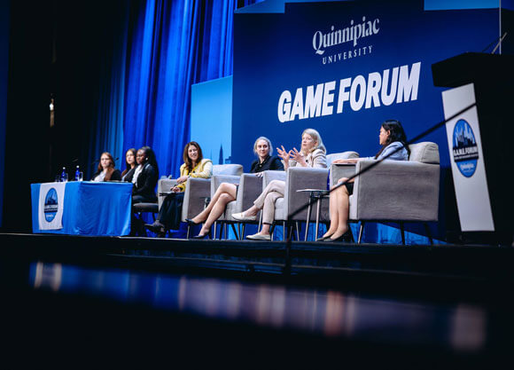 Panelists speak on a stage at GAME Forum.