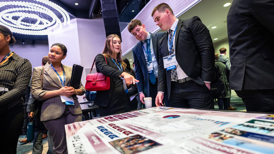 Student attendees observe competing schools' portfolio poster presentations.