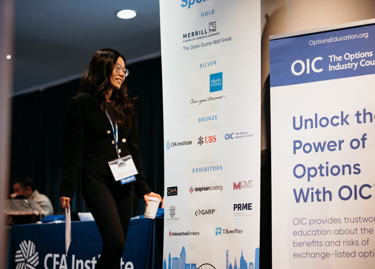A GAME Forum attendee walking by signage featuring 2025 sponsors.