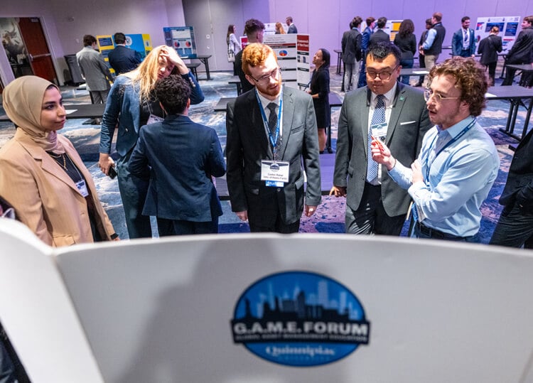 GAME Forum attendees present a poster, showcasing their portfolio to students from other universities.